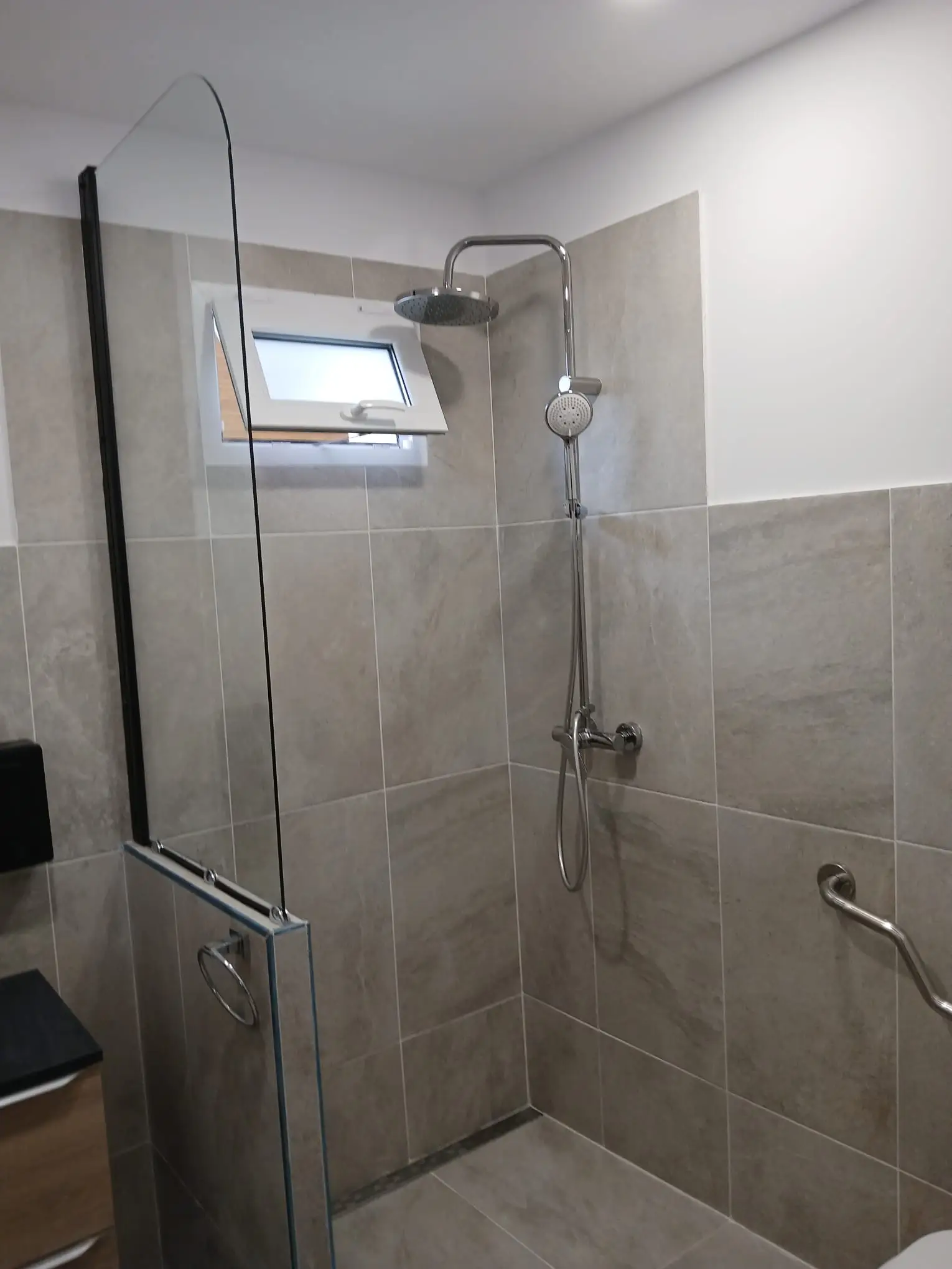 Reforma de baño con plato de ducha a ras de suelo y azulejos porcelánicos grises en A Coruña