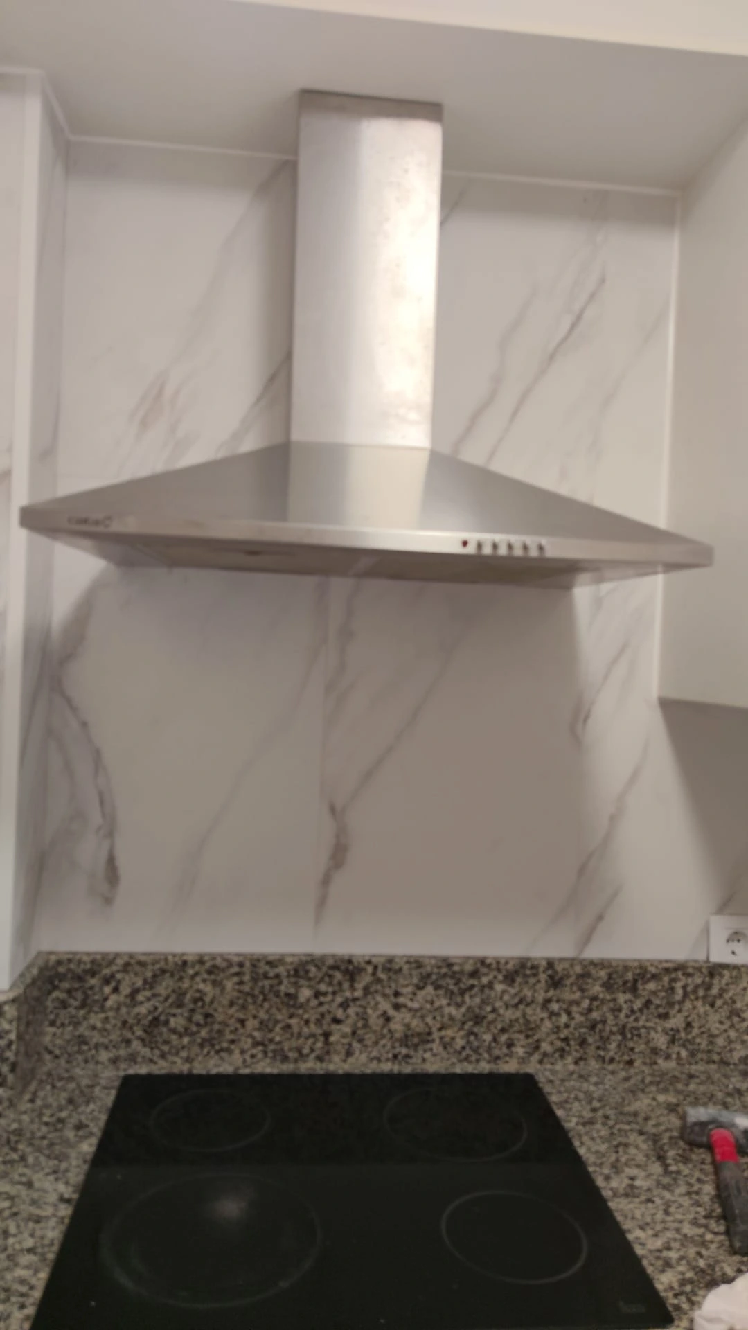 Reforma de cocina con campana de acero inoxidable sobre frente de mármol blanco en A Coruña