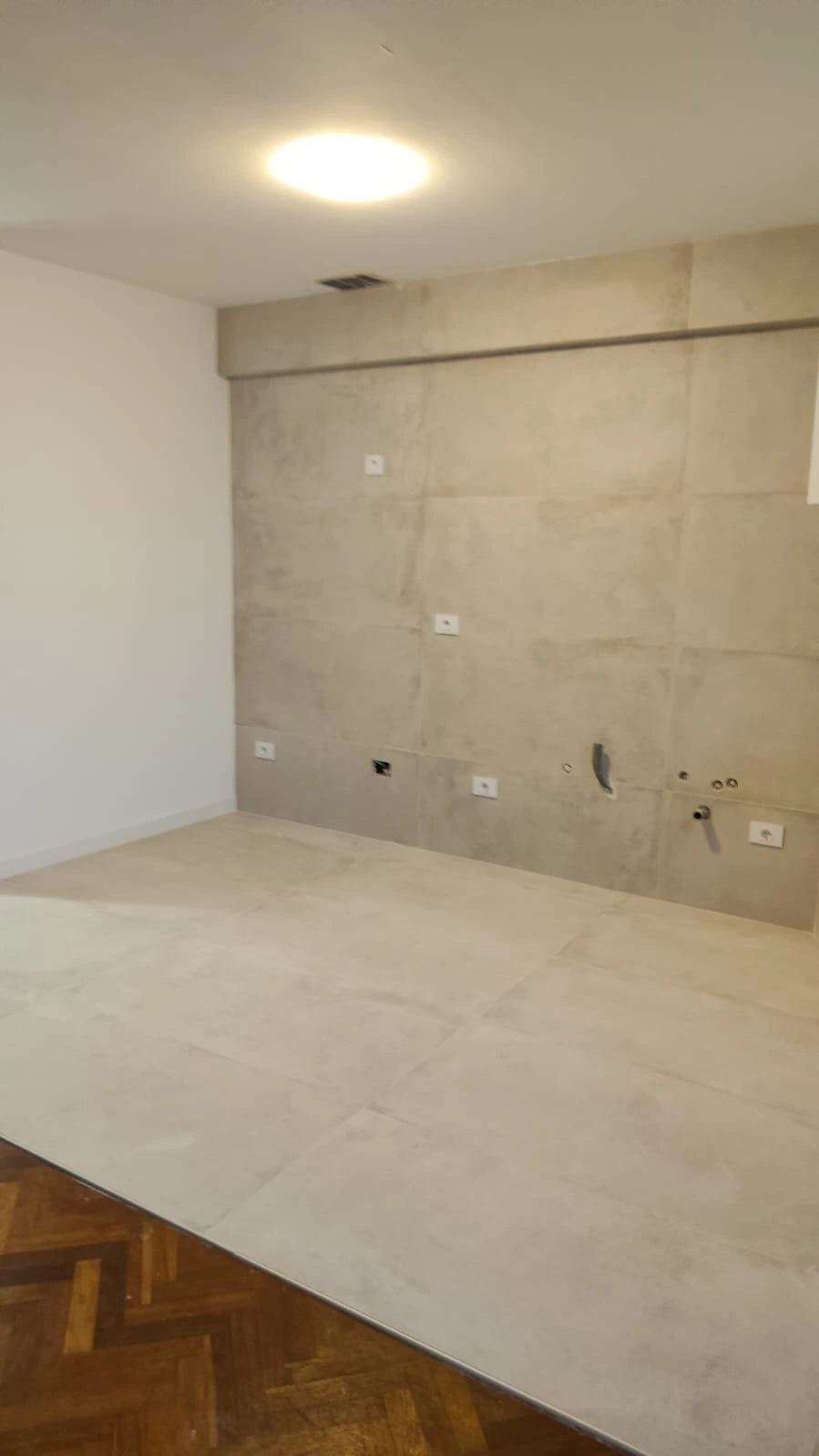 Reforma integral con revestimiento de grandes piezas cerámicas grises en pared y suelo en A Coruña